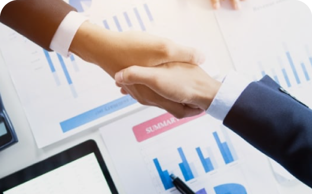 Handshake over business reports and summary charts